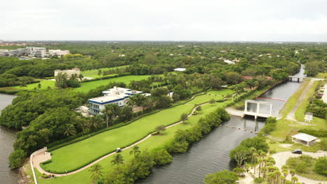 Aerial-view-orbit-over-manicured-waterfront-public-park-on-a-cloudy-day