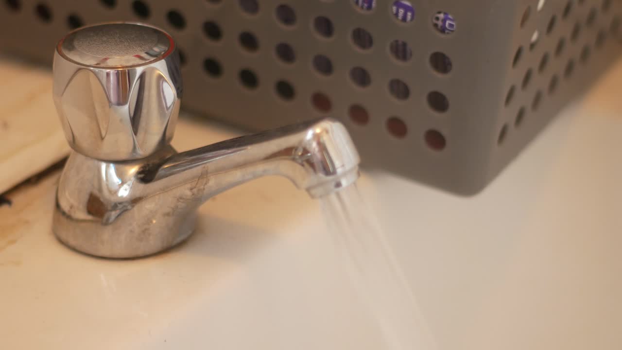 Static shot of chrome tap running hot water bath with steam