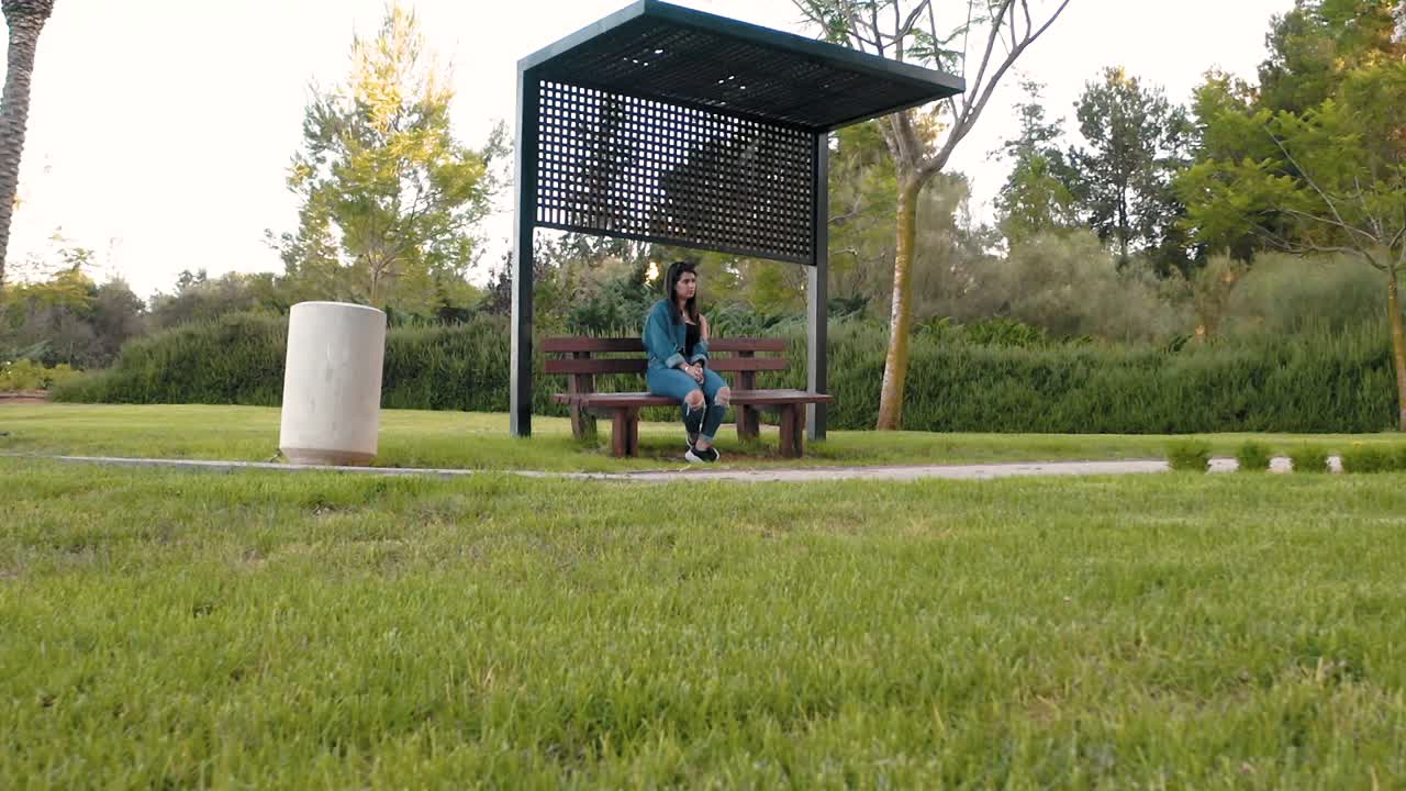 Girl sits on a bench in the park