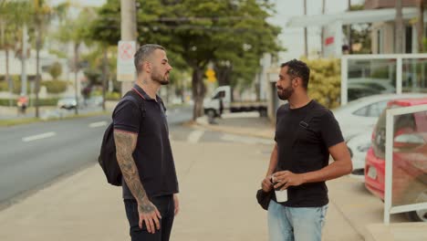two men walking and having a conversation on a city sidewalk