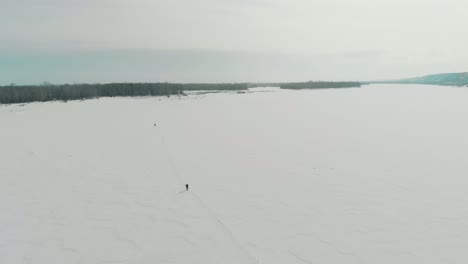 Verschwommene-Menschensilhouetten-Gehen-Den-Weg-Auf-Dem-Zugefrorenen-Fluss-Entlang