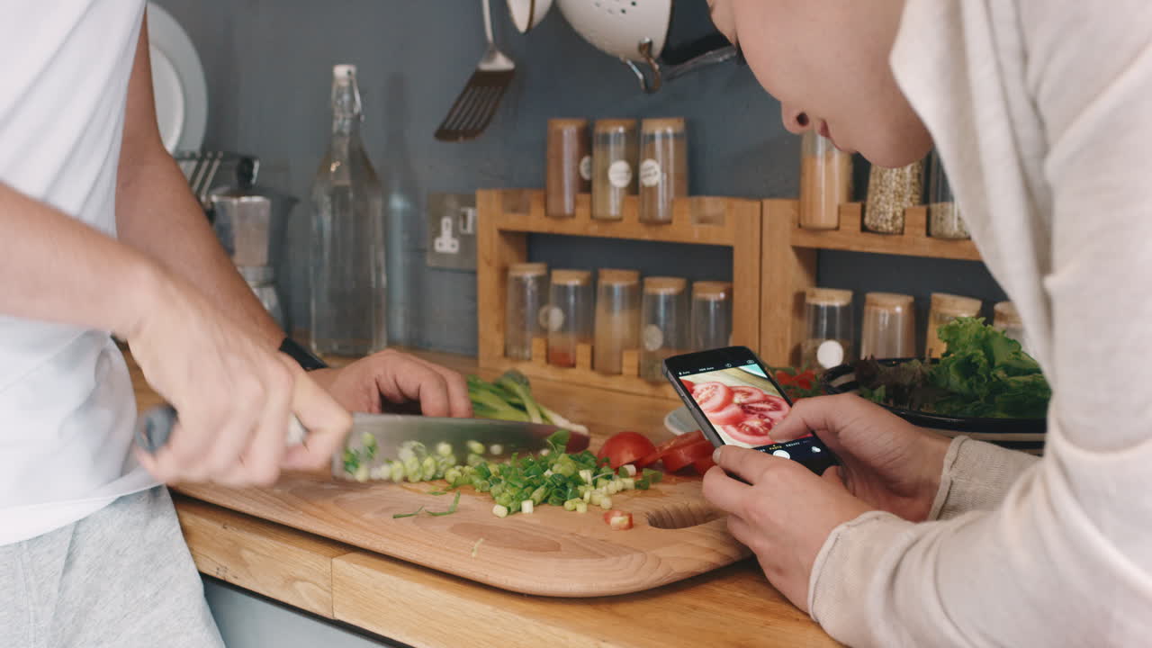 en casa en la cocina por la mañana pareja feliz tomando una foto usando un teléfono inteligente de cortar ensalada saludable para el estilo de vida de las redes sociales