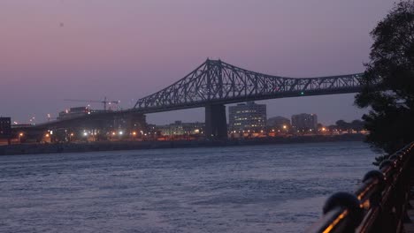 El-Puente-Jacques-Cartier-Y-El-Puerto-De-Montreal-Con-Luces-En-Quebec-Al-Atardecer-Desde-El-Otro-Lado-Del-Río-San-Lorenzo