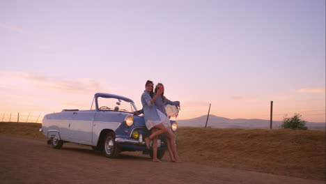 beautiful-Girl-friends-taking-selfies-on-road-trip-at-sunset-with-vintage-car