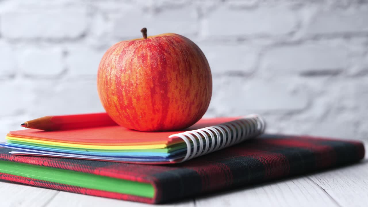 manzana en la pila de cuadernos