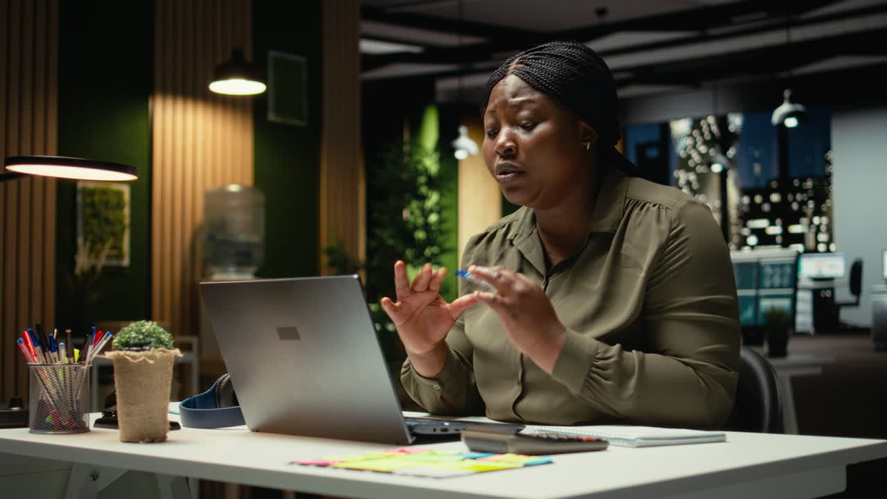 Black businesswoman greeting people on a video call network at office smiling
