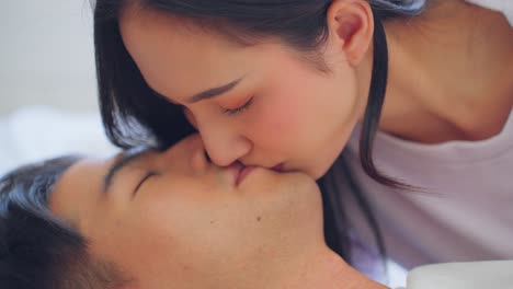 couple kissing and smiling in bed