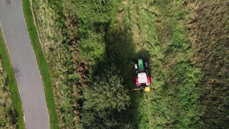 tractor en el campo recortando setos, vista aérea tiro de seguimiento cenital