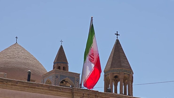 Bandiera iraniana che sventola sopra l'architettura di una chiesa storica