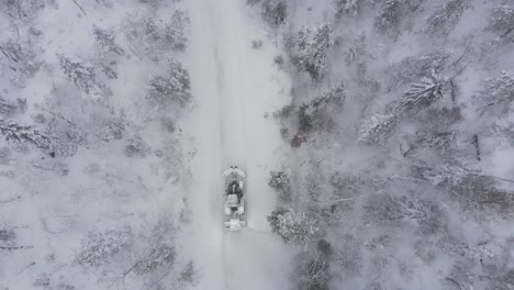 above view of tractor removing thick snow in winterly rural road