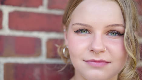 extreme close up of a girl's eyes and face outside agianst a brick wall