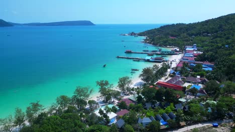 koh rong island with crystal clear turquoise waters, white sandy beach, and a vibrant fishing village nestled along the coastline. perfect aerial view flight overflight flyover drone