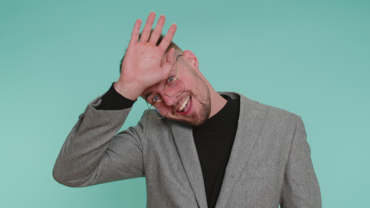 Funny joyful man making playful silly facial expressions grimacing fooling around showing tongue