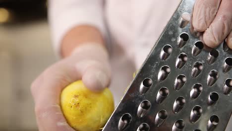 chef grating a citrus fruit