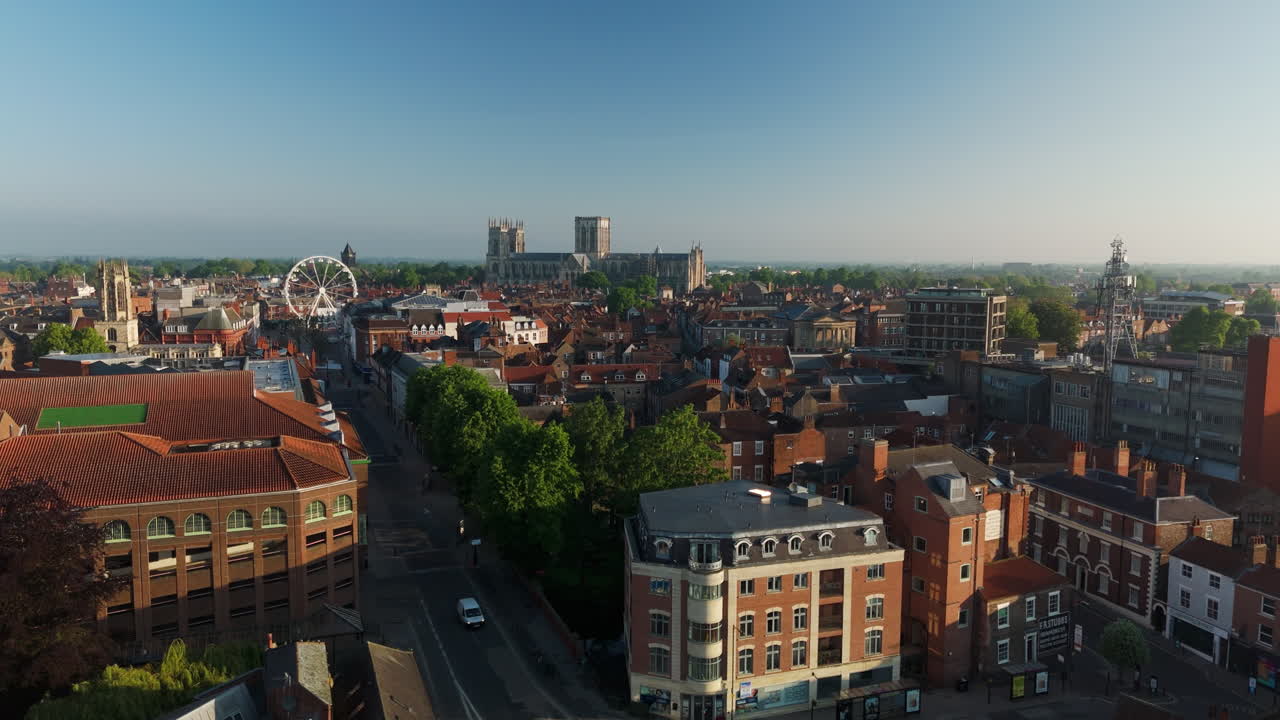 요크 시의 지붕들 사이에서 빛 날 영국에서 요크 미네스터를 배경으로 촬영 된 공중 드론을 설정합니다.