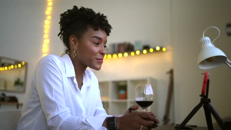mujer negra hablando en video chat en casa y tomando notas