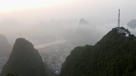 4k drone through mountains around tv tower above the misty clouds guilin