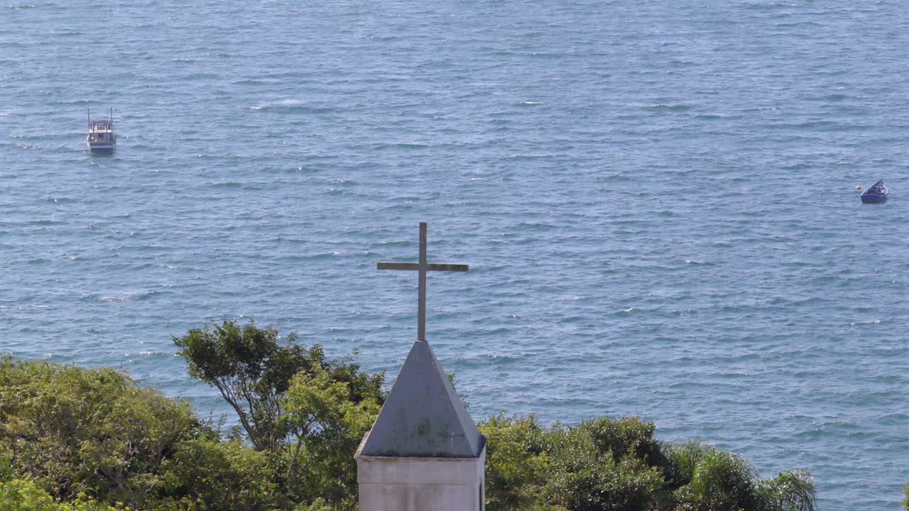 Cross of Nossa Senhora da Imaculada Conceição Chapel with Atlantic Ocean and boats in the background, Bombinhas, Brazil