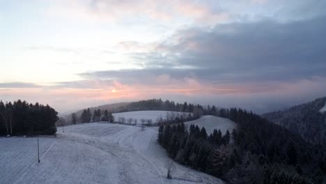 aerial view of snowy hills during sunset.