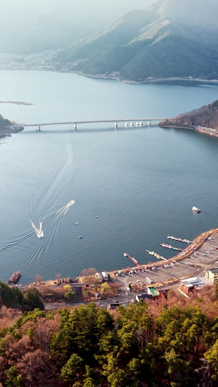 Aerial drone view of boats moving on Lake Kawaguchiko near the Fujikawaguchiko town, Japan
