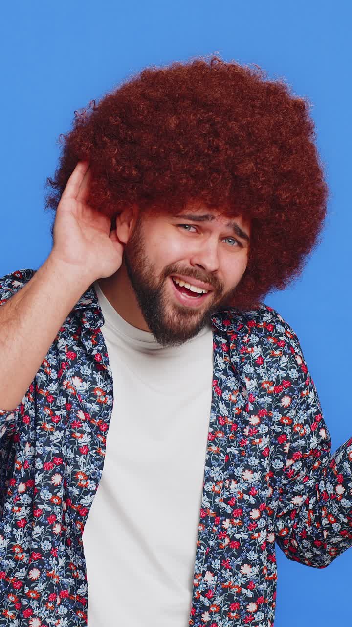 Uomo caucasico che cerca di sentirti con lo sguardo confuso e accigliato che tiene il braccio vicino all'orecchio per una voce più forte