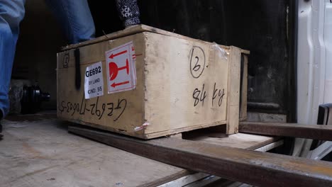 loading wooden crate into a truck