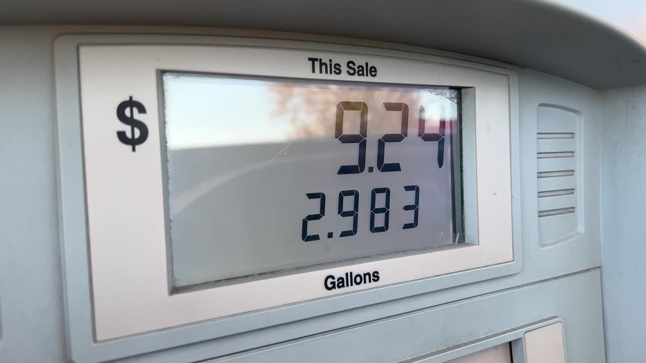 Screen of a gas pump showing the digital numbers going up in price as customer pumps fuel video clip has an authentic handheld vibe