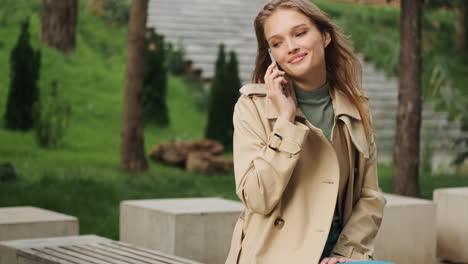 caucasian female student talking on the phone outdoors.