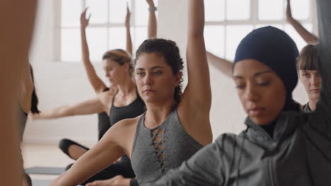 healthy yoga woman practicing seated side bend pose young caucasian female enjoying fitness lifestyle exercising in studio with group of multiracial women