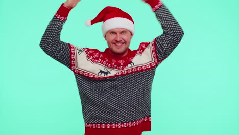 Man-in-sweater-Santa-Christmas-hat-dancing-trendy-dance-for-social-media-fooling-around-having-fun