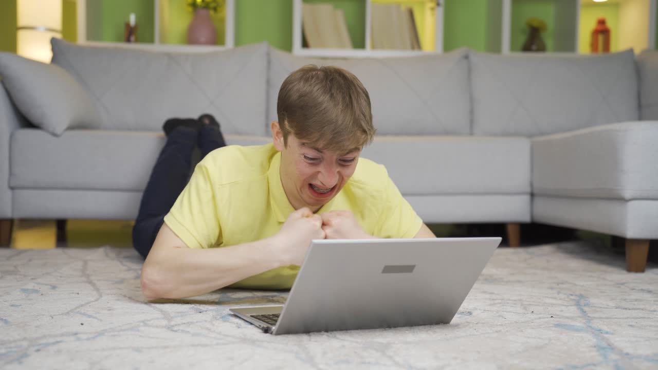 joven fallando en la computadora portátil en casa.