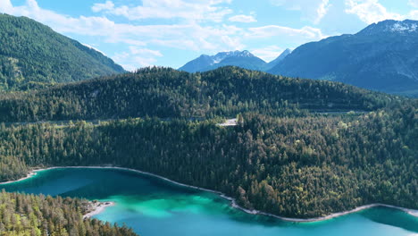 beautiful turquoise lake surrounded by the rocks covered with pine-tree forests. drone flight over the stunning wild nature of europe.