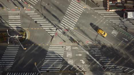 Aerial-birds-eye-overhead-top-down-ascending-footage-of-pedestrians-crossing-street-on-large-intersection.-Sunny-day-in-city.-Manhattan,-New-York-City,-USA