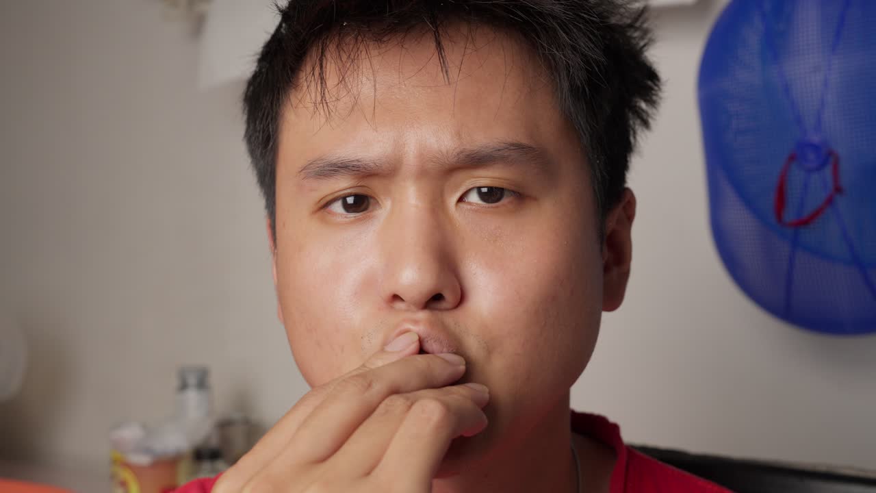 Man enjoys a chocolate treat indoors in a relaxed setting with soft lighting and neutral background