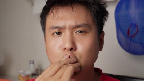 man enjoys a chocolate treat indoors in a relaxed setting with soft lighting and neutral background