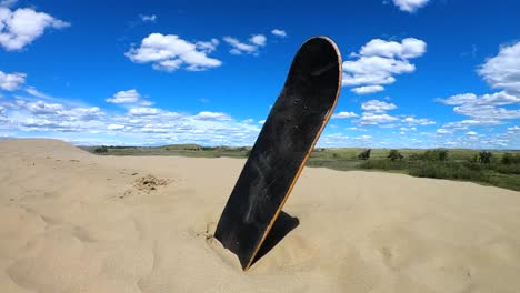 skateboard deck sitting in sand at the alberta sand dunes on a sunny day.