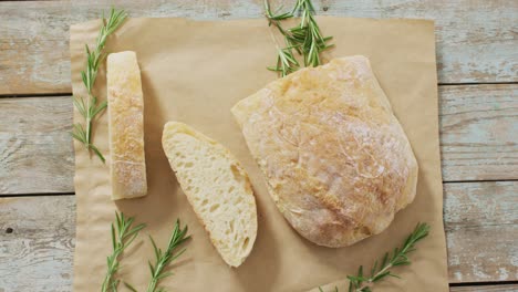 video of rosemary and brad on baking paper on wooden worktop