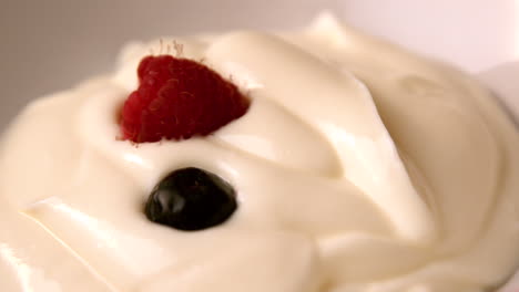 Berries falling onto whipped cream