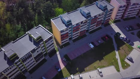 aerial birdseye view of crowded residential district apartment buildings on a sunny summer day, renovated and insulated houses, colorful walls of the facade, wide angle drone dolly shot moving right