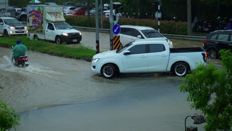 cars, motorscooters and trucks driving through blank streets after heavy rainfall, hat yai, thailand