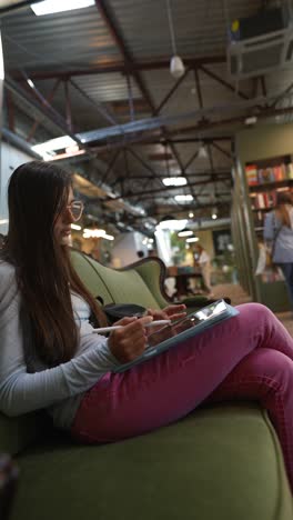 una mujer joven dibujando en una tableta en un acogedor café