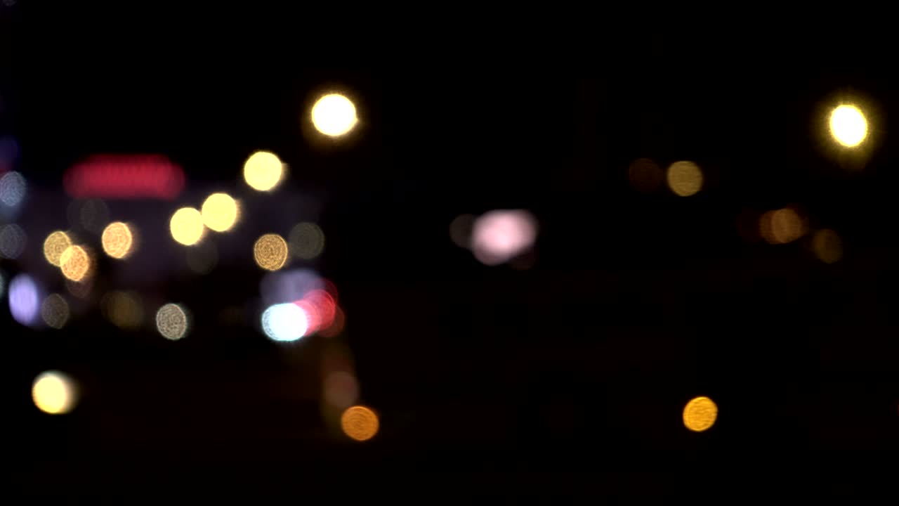 luces desenfocadas calle de los ángeles resumen. fondo borroso de la ciudad. círculos de bokeh en movimiento del tráfico nocturno.