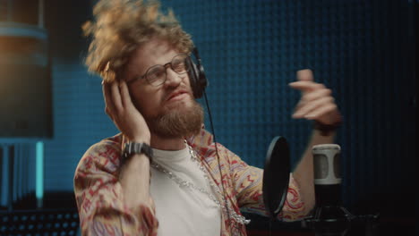 Joven-Hipster-Elegante-Y-Guapo-Cantante-Cantando-Emocionalmente-En-El-Micrófono-Durante-La-Grabación-En-El-Estudio-De-Sonido