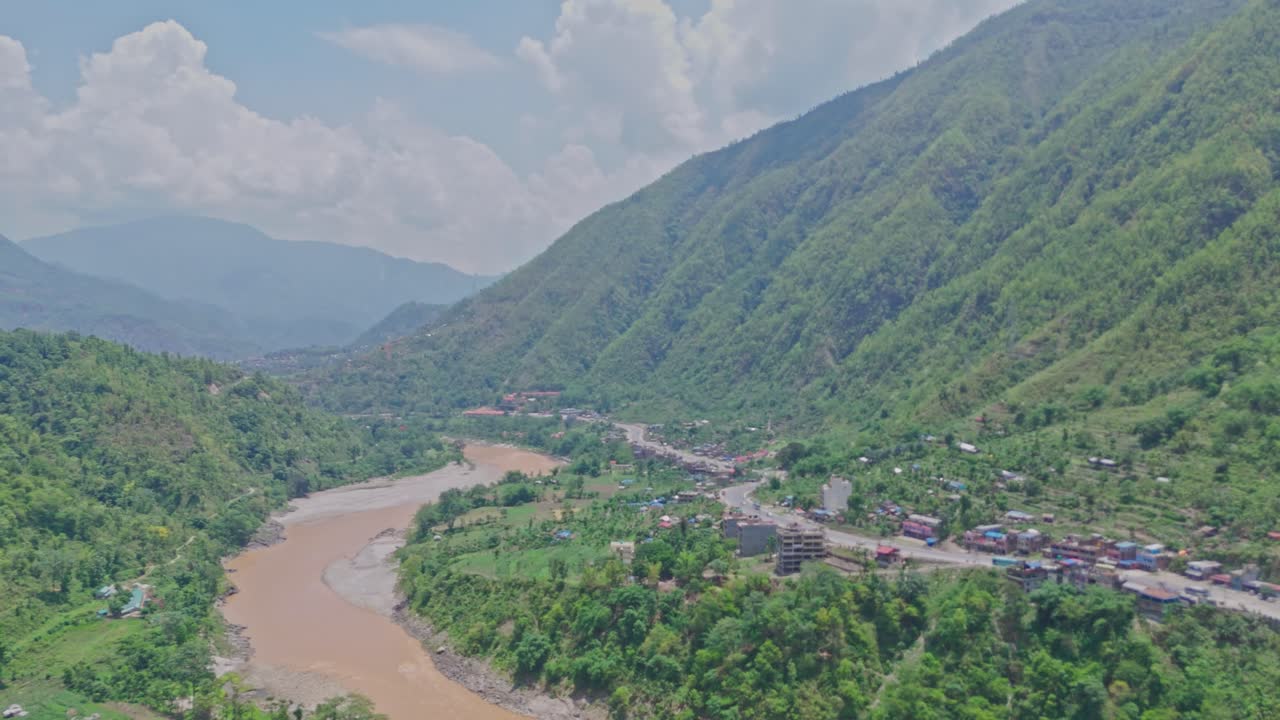 A breathtaking scene of a flowing river winding through lush green mountains, showcasing the beauty of untouched nature. Ideal for travel, environment, relaxation, and scenic landscape footage