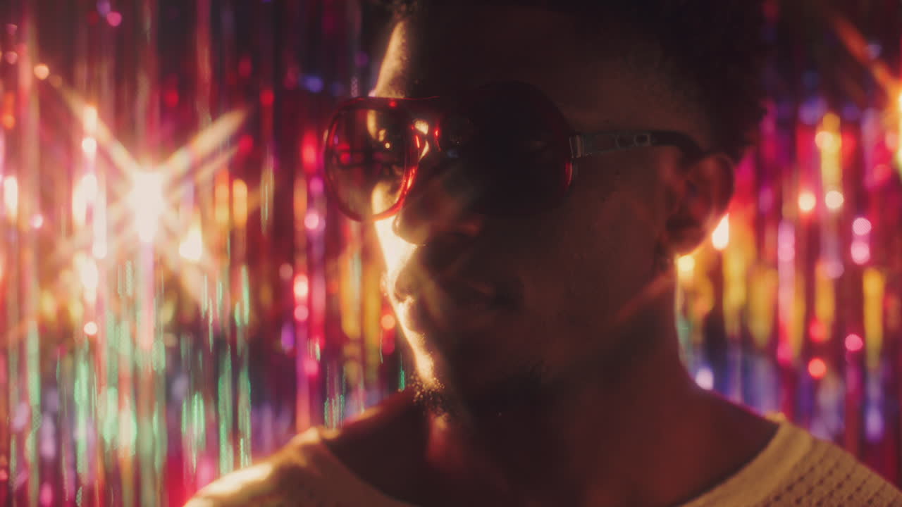 Black Man in Retro Sunglasses under Sparkling Colorful Lights