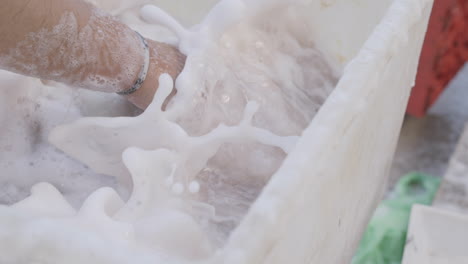 slow motion footage of a man washing an octopus in soapy water off the coast of italy