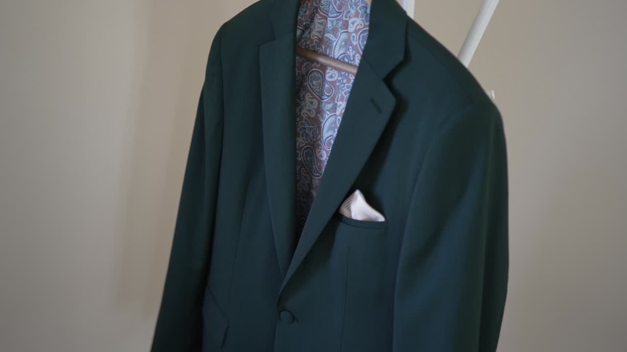 무가 있는 라인과 주머니 사각형이 있는 어두운 초록색 슈트 재이 에 매달려 있습니다.