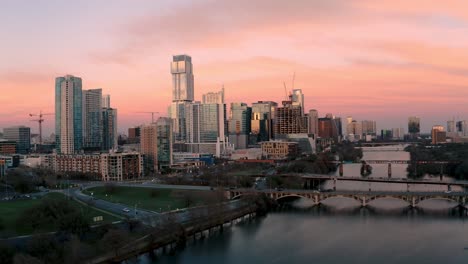 Austin-Texas-Skyline-Bei-Sonnenuntergang-Luftdrohne-Fliegt-über-Stadtsee-Und-Lamarbrücke-In-4k