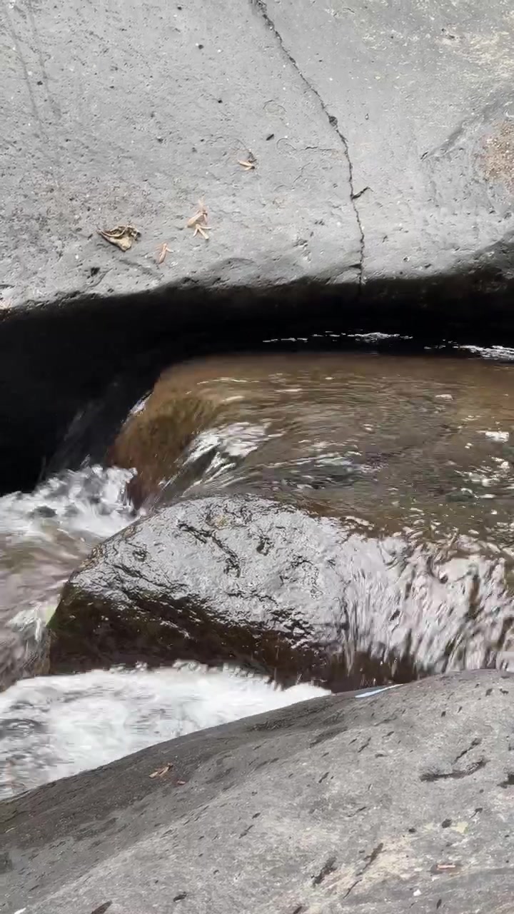 Air Jernih Mengalir Di Atas Bebatuan Sungai yang Halus