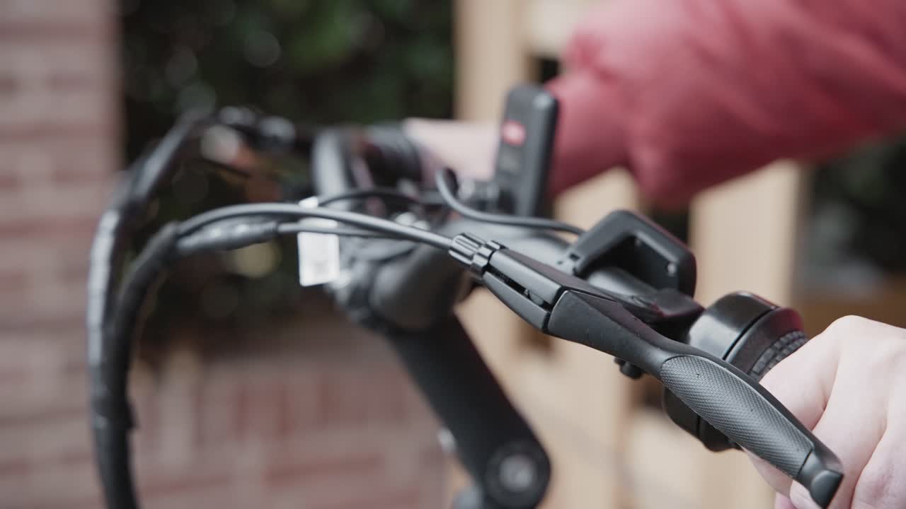 primer plano de una mujer ajustando el ángulo del manillar en una bicicleta eléctrica en un día bien iluminado